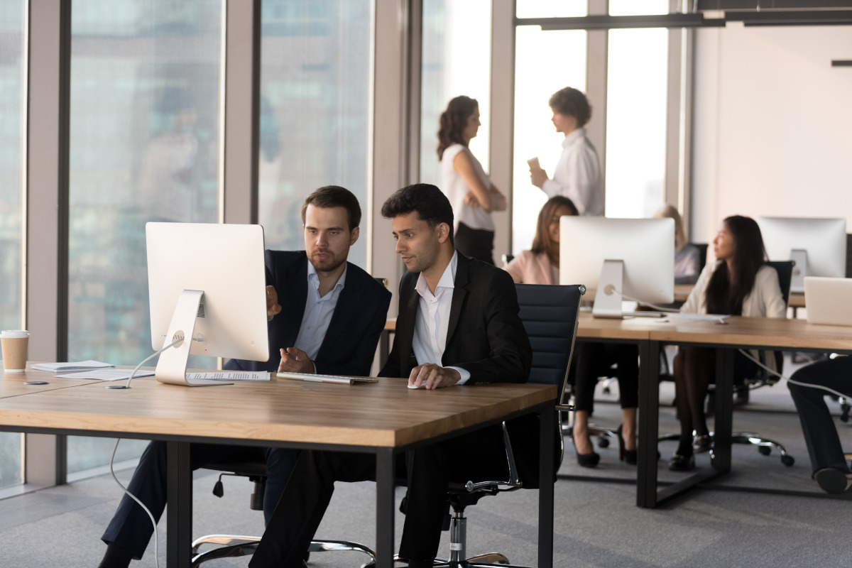 Businessmen working at a computer together