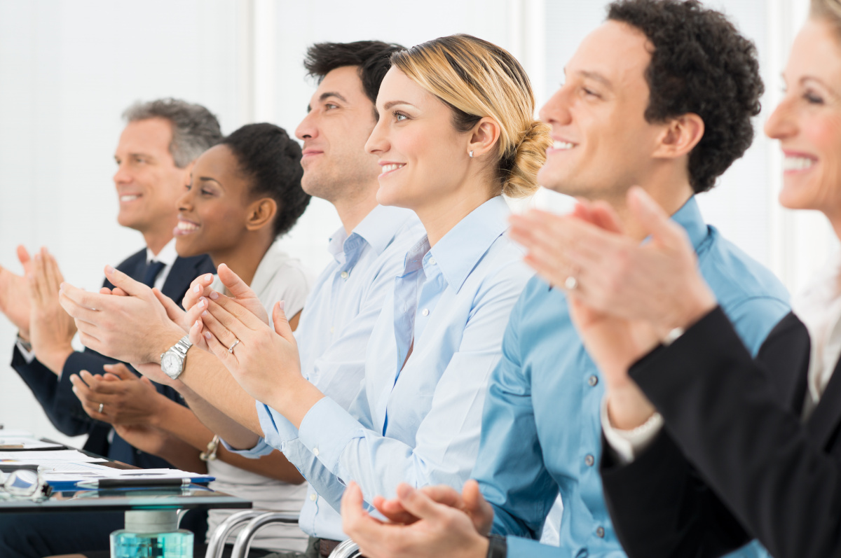 People attending a conference and clapping after a presentation