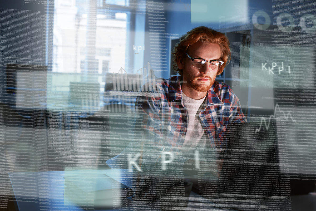 A man working on a computer with the letters KPI (Key Performance Indicators) overlaid