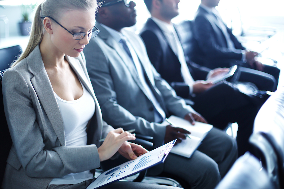 Row of business people working at a seminar.