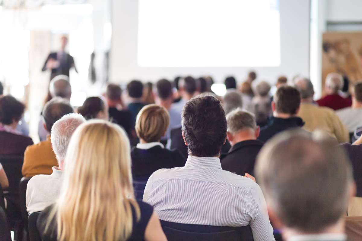 A speaker giving a presentation at a business meeting