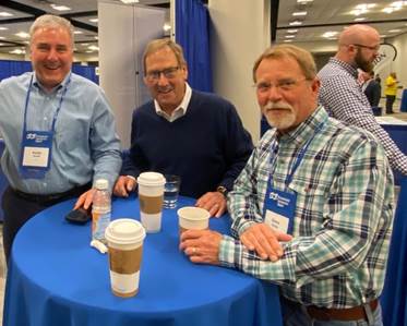 A group of businessmen sitting at a table drinking coffee