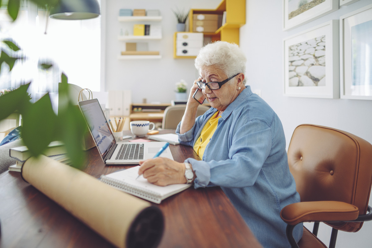 Older woman productively working in front of laptop from her home office